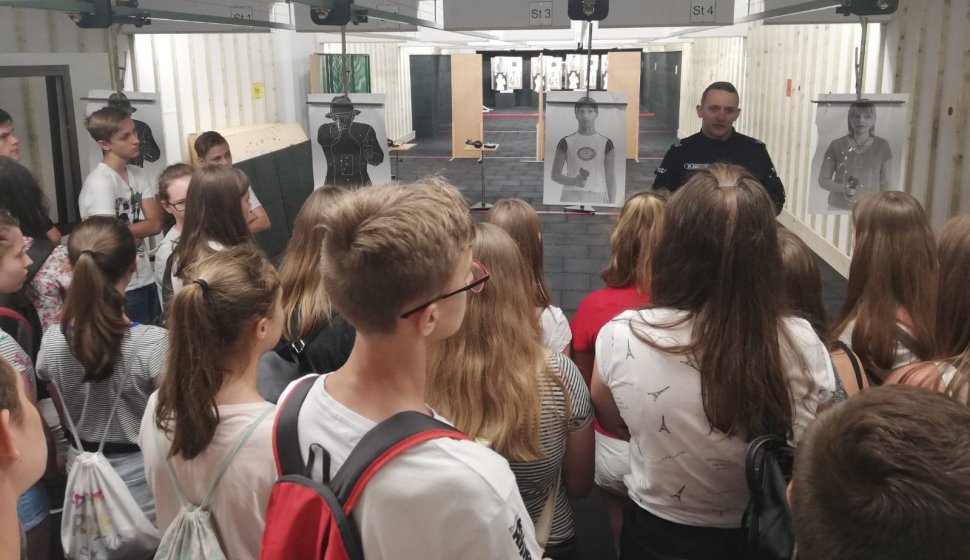 Instruktor wyszkolenia strzeleckiego bielskiej komendy prezentuje uczniom strzelnicę.