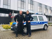 Funkcjonariusz niemieckiej Policji i Policjant z Bielska-Białej stoją na tle radiowozu i komendy.