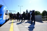 Policjanci zabezpieczają dworzec PKP podczas wyjścia kibiców z pociągu.