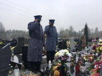 Policjanci oddają honor nad grobem poległego policjanta.