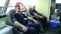 Policjanci oddają krew w mobilnej akcji krwiodawstwa.