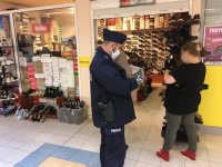 Policjant kontroluje sklep z obuwiem.